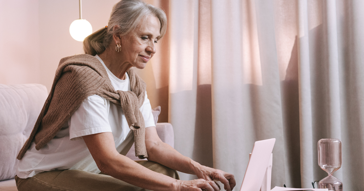 older woman working on computer reviewing her retirement withdrawal strategy
